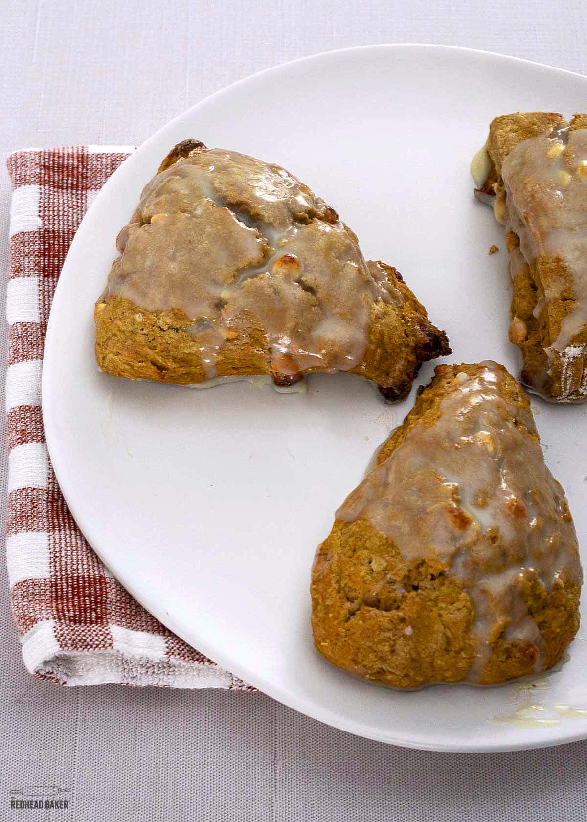 Three pumpkin scones on a white plate.